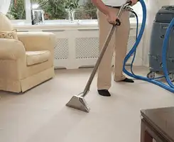 Carpet cleaning professional removing dirt and stains with a hot-water extraction tool in a home, Denver, CO.